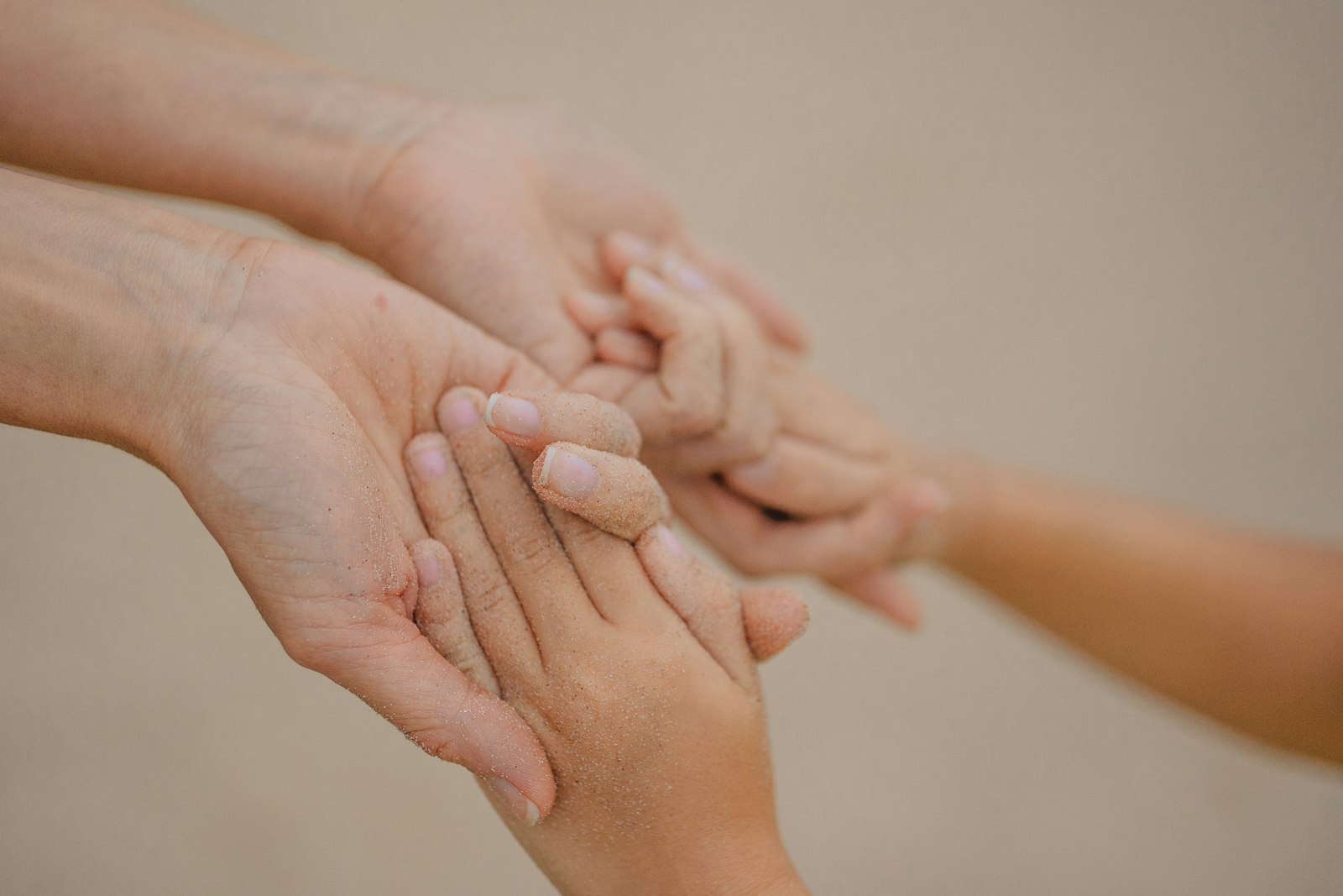 An adult's hands holding a child's hands
